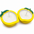 Pair of yellow lemon-shaped candles with green leaves