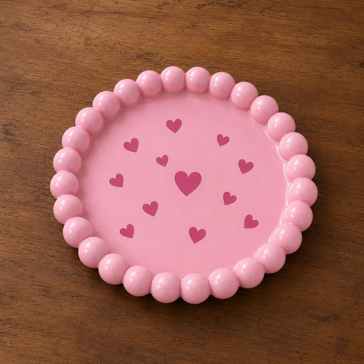 Pink ceramic bubble tray with heart pattern on wooden surface