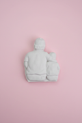 White unpainted plaster Hero Dad and child relief figure on pastel pink surface