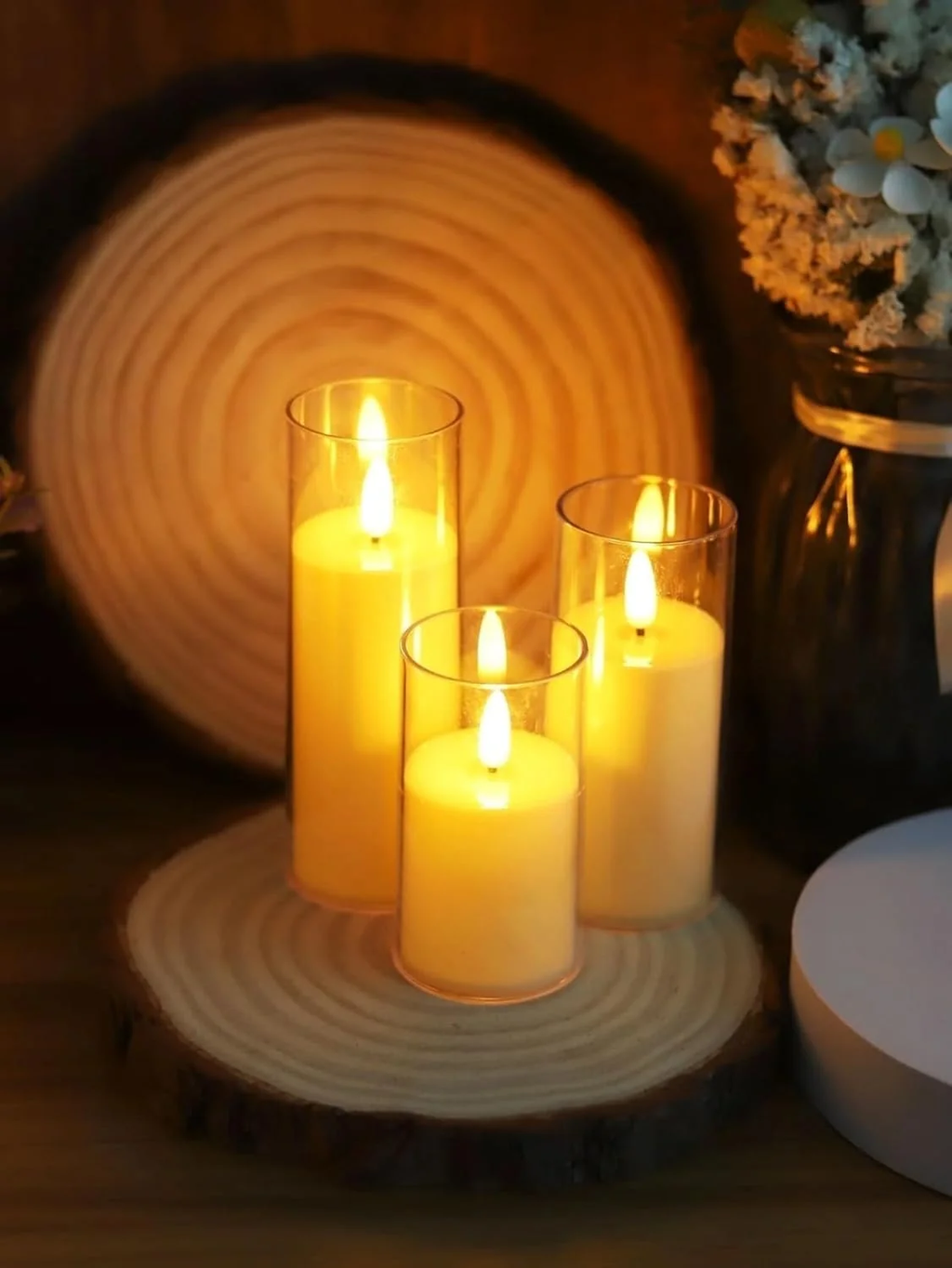 Flameless LED pillar candles glowing on wooden slice display
