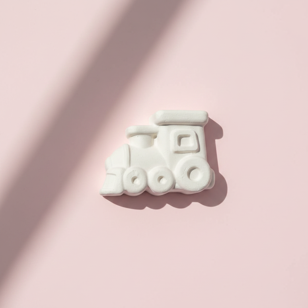 Train engine plaster fridge magnet on pink background