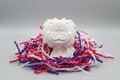 White lion plaster figure with silver background and colourful shredded paper