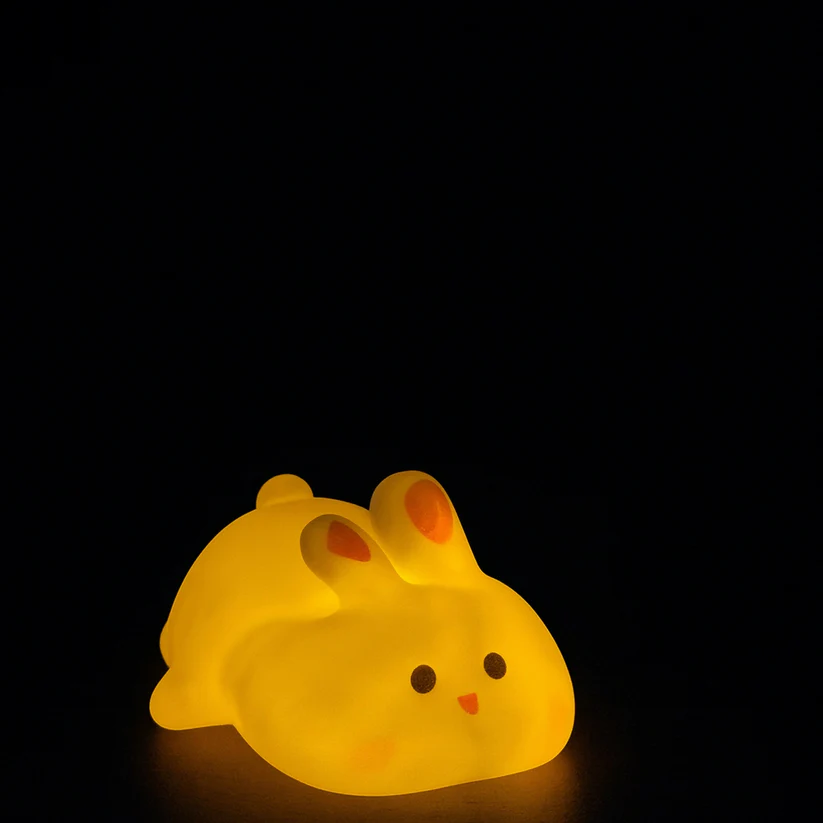 Bunny silicone night light glowing warm golden yellow in the dark