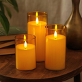 Set of 3 flameless LED pillar candles in glass on wooden table