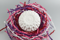 White flower plaster figure with silver background and colourful shredded paper