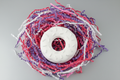 White donut plaster figure beautified with silver background and colourful shredded paper
