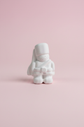 White unpainted plaster soldier figure on pastel pink surface