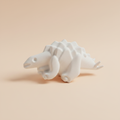 White plaster Stegosaurus dinosaur fridge magnet on soft light peach background